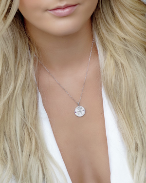 Close-up of the Cvlcha necklace Aquarius Zodiac Silver Necklace worn by a female  with blonde hair.