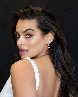 Model wearing Cvlcha Arc Hoops in 14K gold plated sterling silver with natural moonstones.
