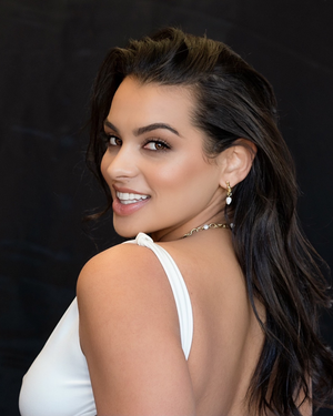 Model smiling wearing Arc Hoops in 14K gold plated sterling silver with natural moonstones