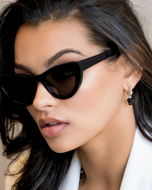 Close up of a women wearing a modern gold hoop earrings featuring natural black onyx gemstones suspended from textured hoops, designed for everyday wear by CVLCHA.