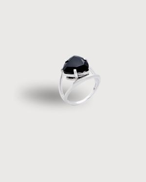 CVLCHA Silver cocktail  ring with a large Trillion cut black gemstone on a light gray background