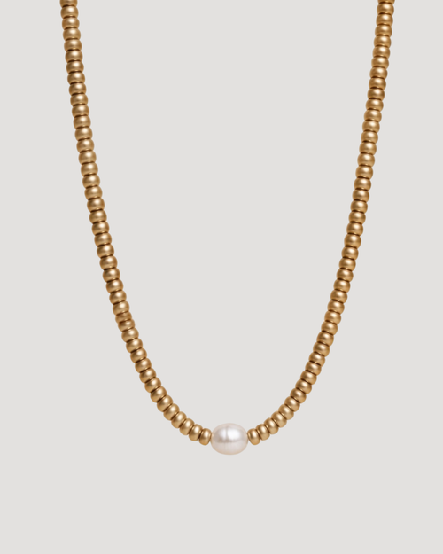 CVLCHA Solene Signature Gold pearl  necklace with a single pearl on a light gray background