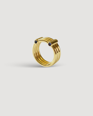 Cvlcha Adira gold Ring with multi bands and embedded gemstones on a light Gray background
