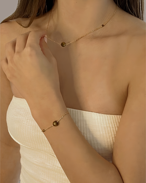 Female wearing Cvlcha Iris Tiger Eye gemstone Pendant Gold Necklace and Bracelet