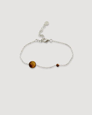 A delicate silver chain bracelet featuring a large round brown tiger's eye stone and a smaller reddish-brown bead, displayed on a light gray background.
