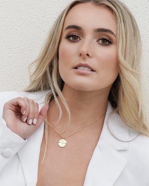 Female wearing a CVLCHA Libra Gold Necklace against a light background