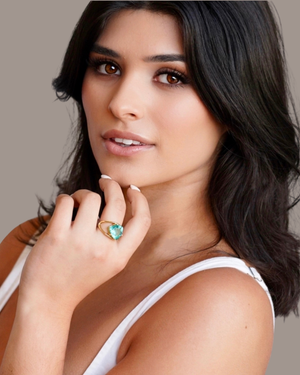 Female wearing the Cvlcha Lilly Gold ring with a striking trillion cut 5A green colour zirconia 