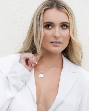 Model showcasing CVLCHA Scorpio Zodiac Silver Necklace with white blazer