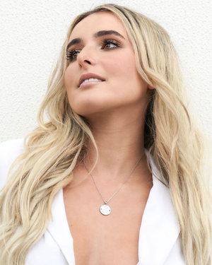 Female wearing CVLCHA Scorpio Zodiac Silver Necklace with white blazer