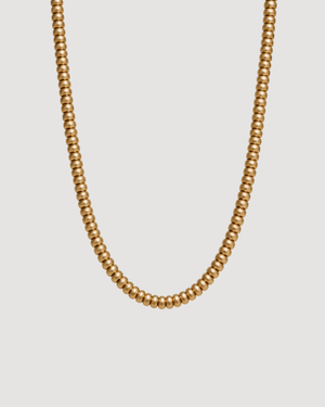 Gold Pearl necklace on a light grey background