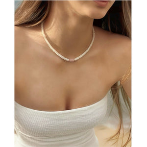 sandra rose quartz gemstone surrounded by white coral